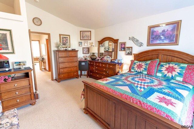 bedroom featuring light colored carpet and vaulted ceiling