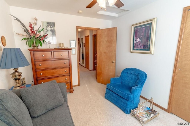 living area featuring light colored carpet and ceiling fan