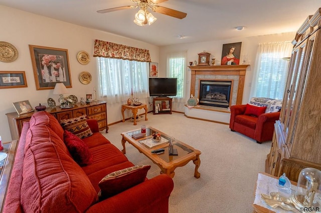 carpeted living room featuring ceiling fan, a wealth of natural light, and a fireplace