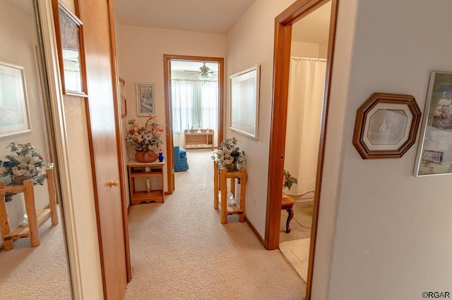 hallway featuring light colored carpet