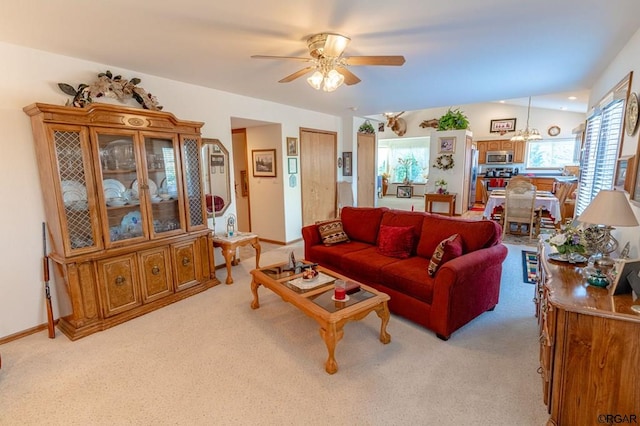 living room with ceiling fan with notable chandelier and light carpet