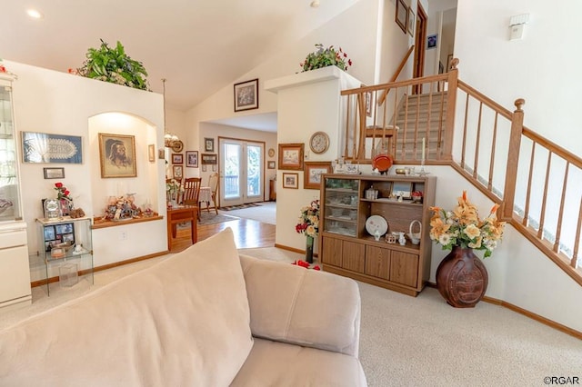 carpeted living room featuring french doors and high vaulted ceiling