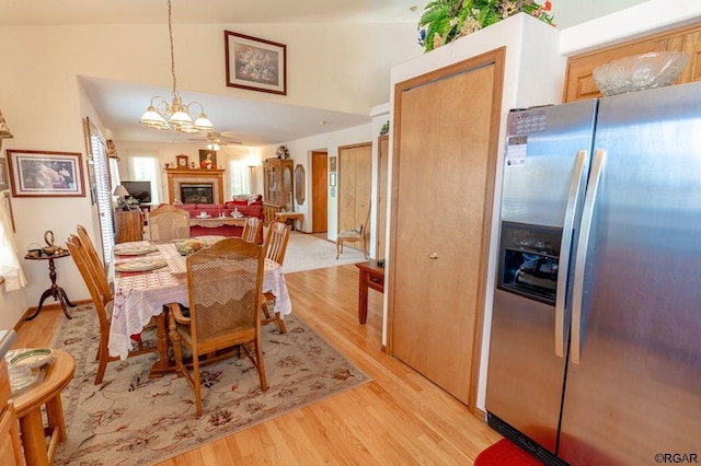 dining area featuring an inviting chandelier, lofted ceiling, and light hardwood / wood-style floors