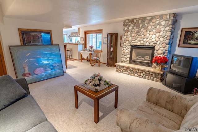 living room featuring a stone fireplace and carpet floors