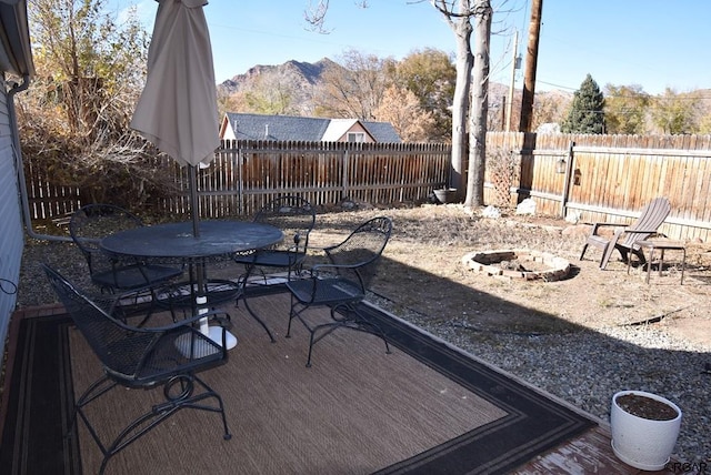 view of patio / terrace featuring a deck with mountain view and a fire pit