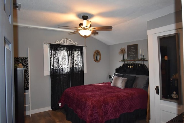 bedroom featuring dark wood-type flooring, ceiling fan, and vaulted ceiling