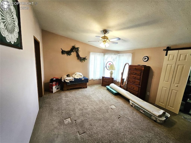 bedroom with a textured ceiling, carpet flooring, and ceiling fan
