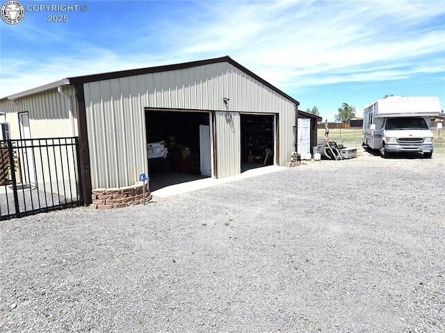 detached garage featuring fence