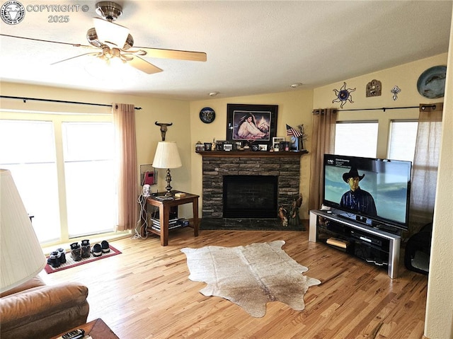 living room with healthy amount of natural light, wood finished floors, a textured ceiling, and vaulted ceiling