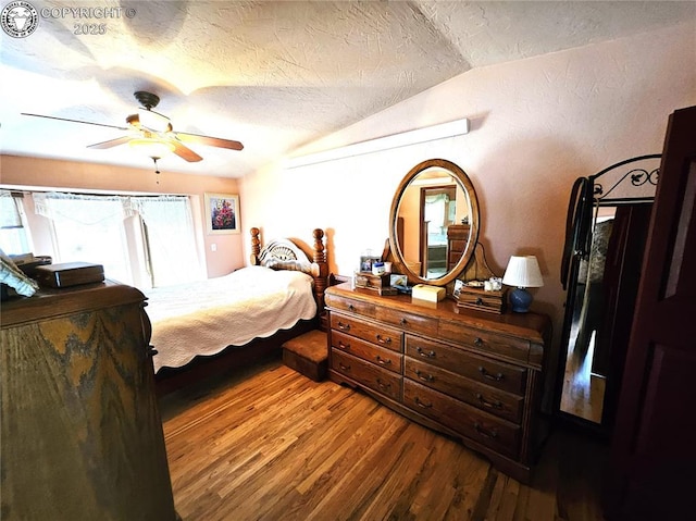 bedroom featuring vaulted ceiling, wood finished floors, a textured ceiling, and a ceiling fan