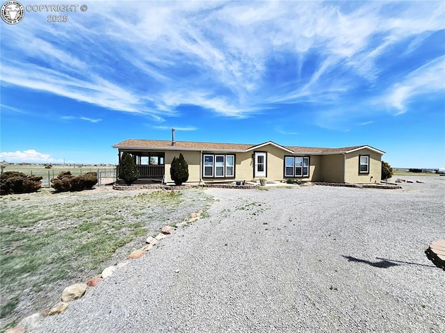 manufactured / mobile home with stucco siding and fence