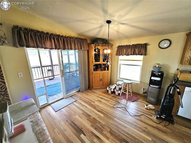 dining area featuring light wood-type flooring and a textured ceiling