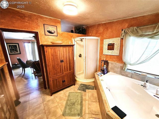 full bath featuring a stall shower, a bath, a textured ceiling, and tile patterned floors