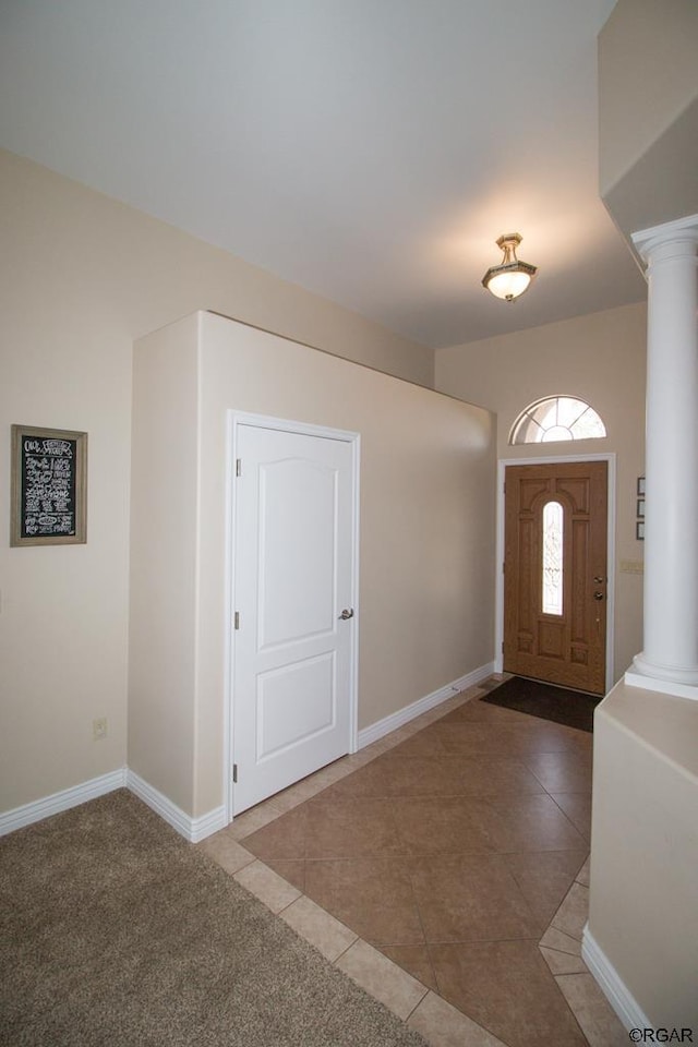 tiled foyer featuring decorative columns