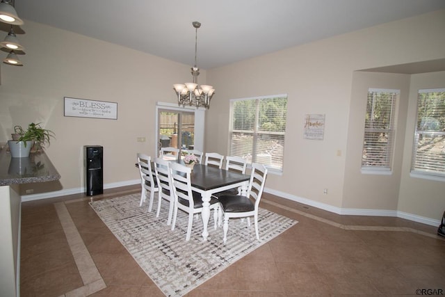 tiled dining area featuring an inviting chandelier