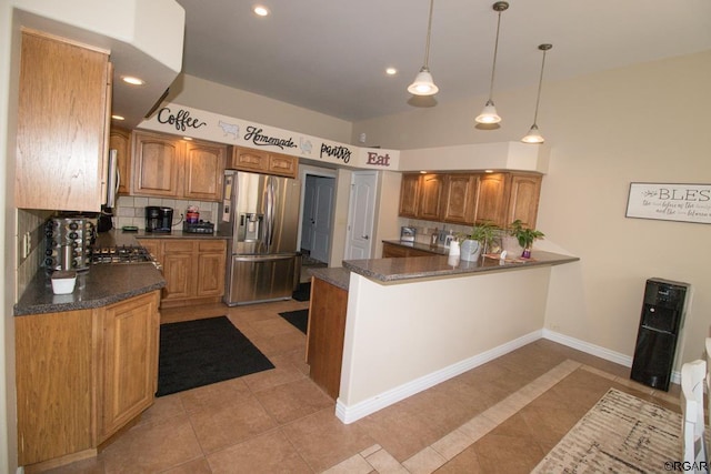 kitchen featuring pendant lighting, stainless steel fridge, decorative backsplash, light tile patterned floors, and kitchen peninsula