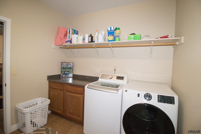 clothes washing area featuring cabinets and washer and dryer