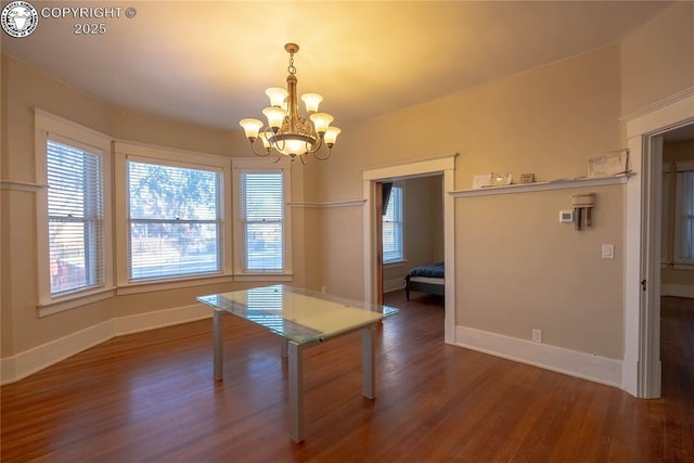 unfurnished dining area with dark wood-type flooring and a chandelier