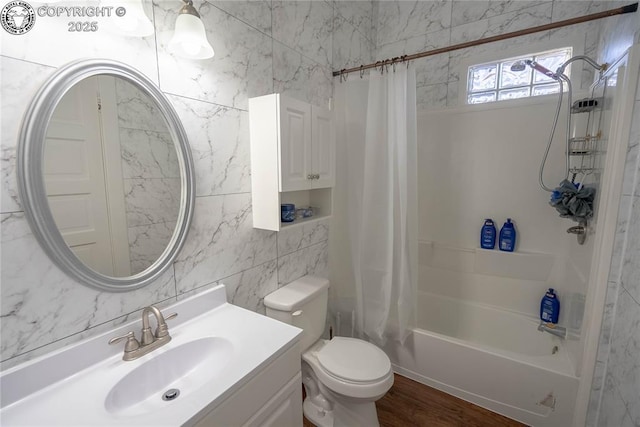 full bathroom with tile walls, shower / bath combination with curtain, hardwood / wood-style flooring, vanity, and toilet