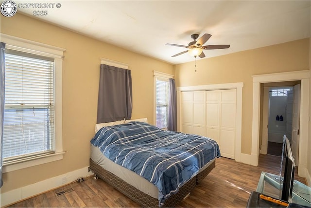 bedroom with dark hardwood / wood-style floors, ceiling fan, and a closet