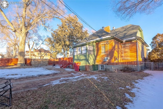 view of snow covered rear of property