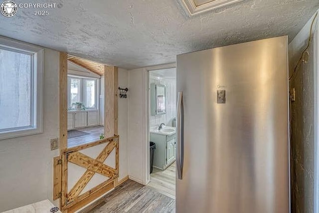 interior space featuring a sink, a textured ceiling, and wood finished floors