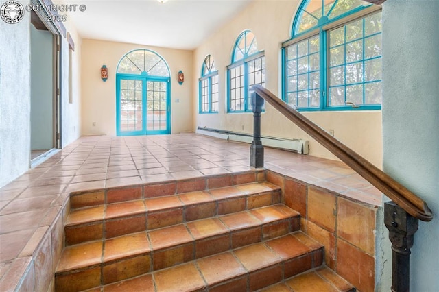 stairs featuring french doors and a baseboard heating unit