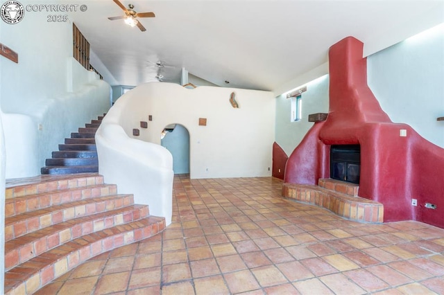 living room featuring a ceiling fan, stairs, and vaulted ceiling