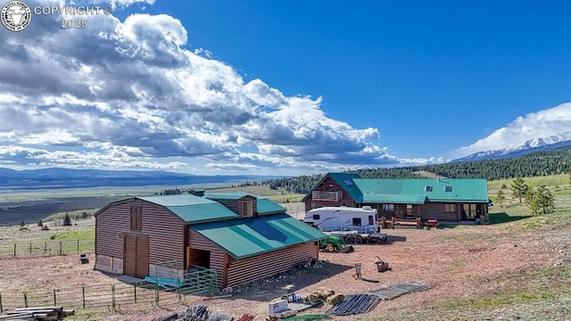 view of outdoor structure featuring a mountain view, fence, and an outdoor structure