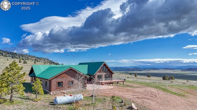 exterior space featuring metal roof, a mountain view, and log exterior