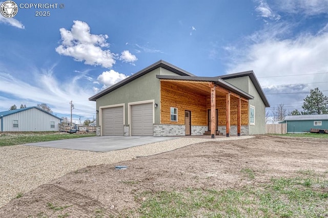 806 S St, Silver Cliff, CO 81252 - view of home's exterior featuring driveway, stone siding, an attached garage, and stucco siding