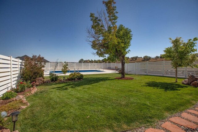 view of yard with a fenced in pool