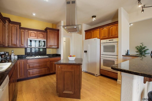 kitchen featuring a kitchen island, decorative backsplash, light wood-type flooring, and appliances with stainless steel finishes