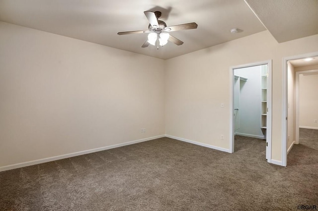 unfurnished room featuring ceiling fan and dark colored carpet