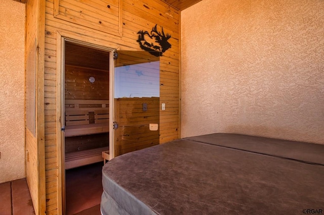 bedroom featuring wood walls