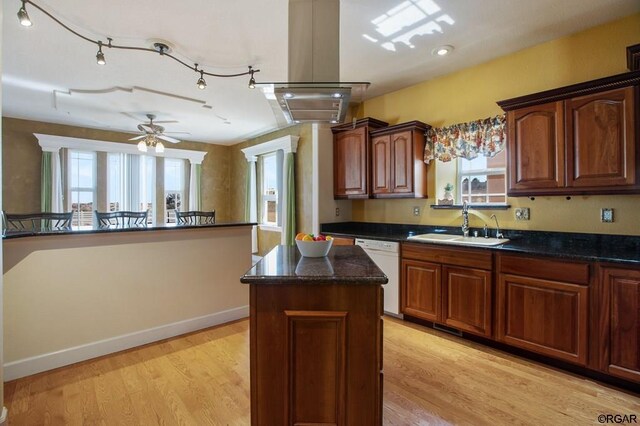 kitchen with sink, white dishwasher, a kitchen island, ceiling fan, and light hardwood / wood-style floors