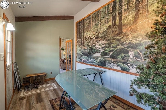 dining room featuring lofted ceiling with beams and wood-type flooring