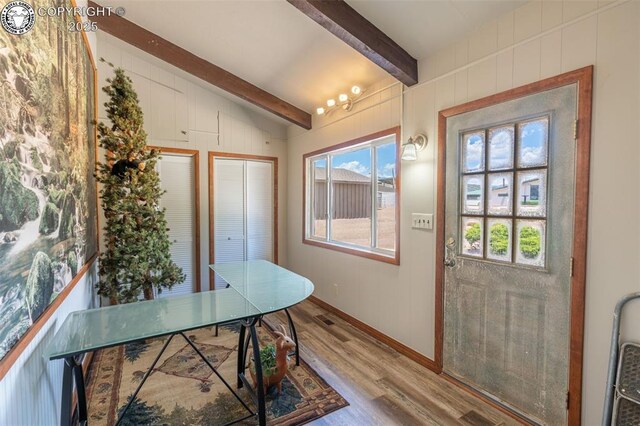 doorway featuring lofted ceiling with beams and wood-type flooring