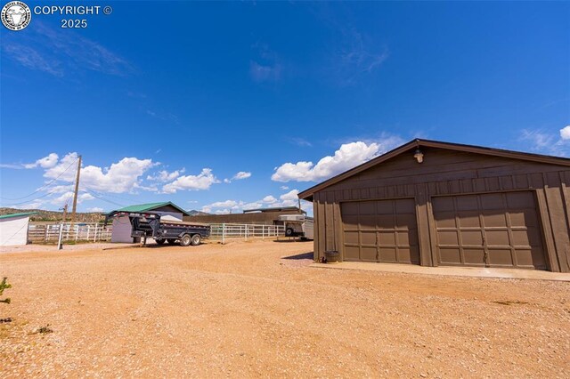 view of yard featuring a garage and an outdoor structure