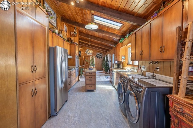 washroom with wood walls, a skylight, sink, independent washer and dryer, and wooden ceiling