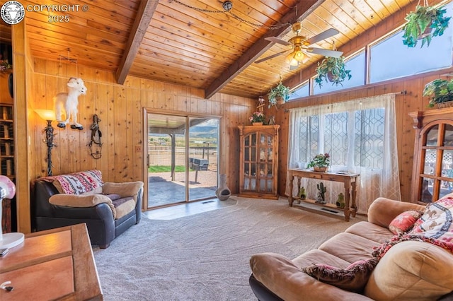 carpeted living room with beamed ceiling, wooden walls, high vaulted ceiling, and wooden ceiling