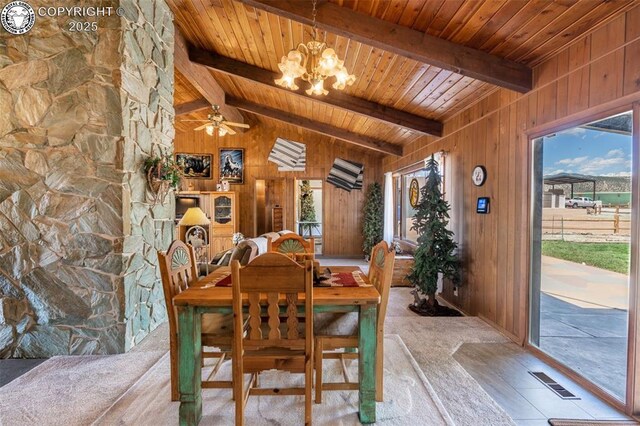 dining space with vaulted ceiling with beams, wooden ceiling, a chandelier, and wood walls