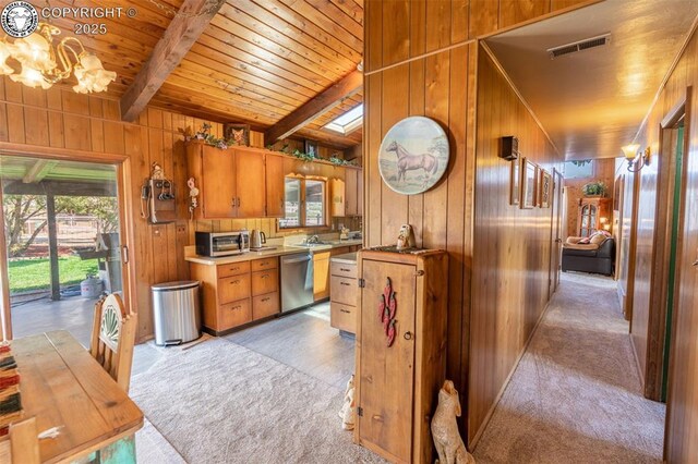 kitchen featuring wood ceiling, dishwasher, wooden walls, light colored carpet, and beamed ceiling