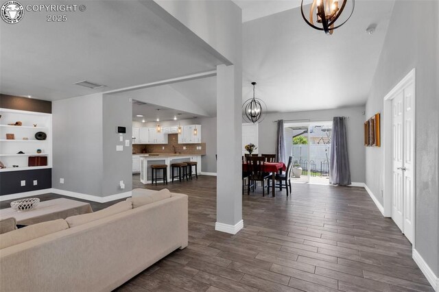 717 Tyrolean Way, Canon City, CO 81212 - living area featuring a chandelier, dark wood finished floors, baseboards, and built in shelves