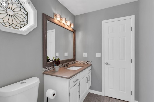 717 Tyrolean Way, Canon City, CO 81212 - bathroom featuring toilet, vanity, baseboards, and wood finished floors