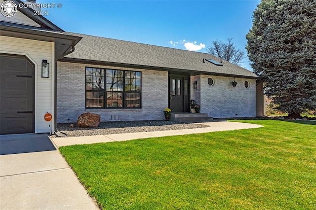 717 Tyrolean Way, Canon City, CO 81212 - view of front of home with brick siding, a front lawn, roof with shingles, and an attached garage