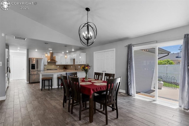 717 Tyrolean Way, Canon City, CO 81212 - dining space with a chandelier, dark wood-type flooring, lofted ceiling, and baseboards