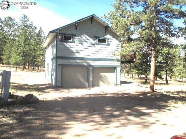 474 Black Fawn Ln, Westcliffe, CO 81252 - view of side of property featuring an attached garage and dirt driveway