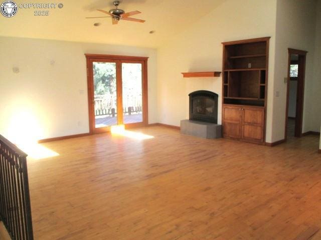 474 Black Fawn Ln, Westcliffe, CO 81252 - unfurnished living room with light wood-style flooring, a ceiling fan, a fireplace with raised hearth, and high vaulted ceiling