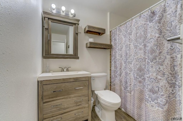 bathroom with vanity, hardwood / wood-style flooring, curtained shower, and toilet